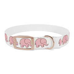 Small dog in cute pink elephant collar posing for camera at dog park